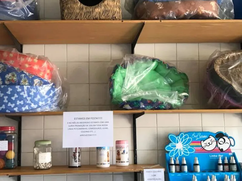 Expositor com coleiras e guias coloridas para cães no pet shop Bichos & Mimos em Pindamonhangaba